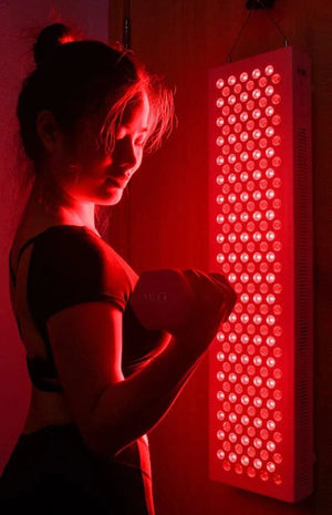 Woman lifting weight with red light therapy panel, BBL2228332