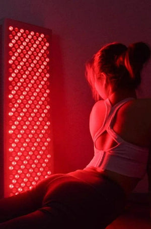 Woman near red light therapy panel