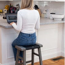 Woman working on laptop in kitchen (MAT-Small_1)