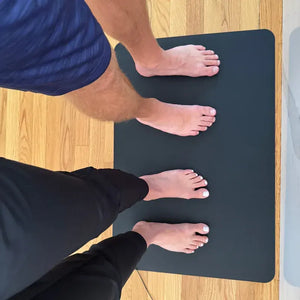 Two people standing on a MATFL_3 foot mat