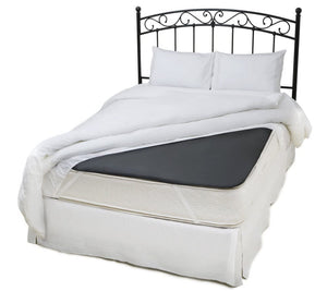 Bed with dark mattress pad and white bedding