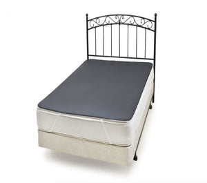 Bed with decorative headboard and gray mattress topper