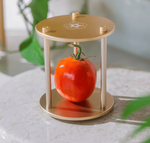 Tomato in decorative gold stand, screenshot Dec 18, 2025.